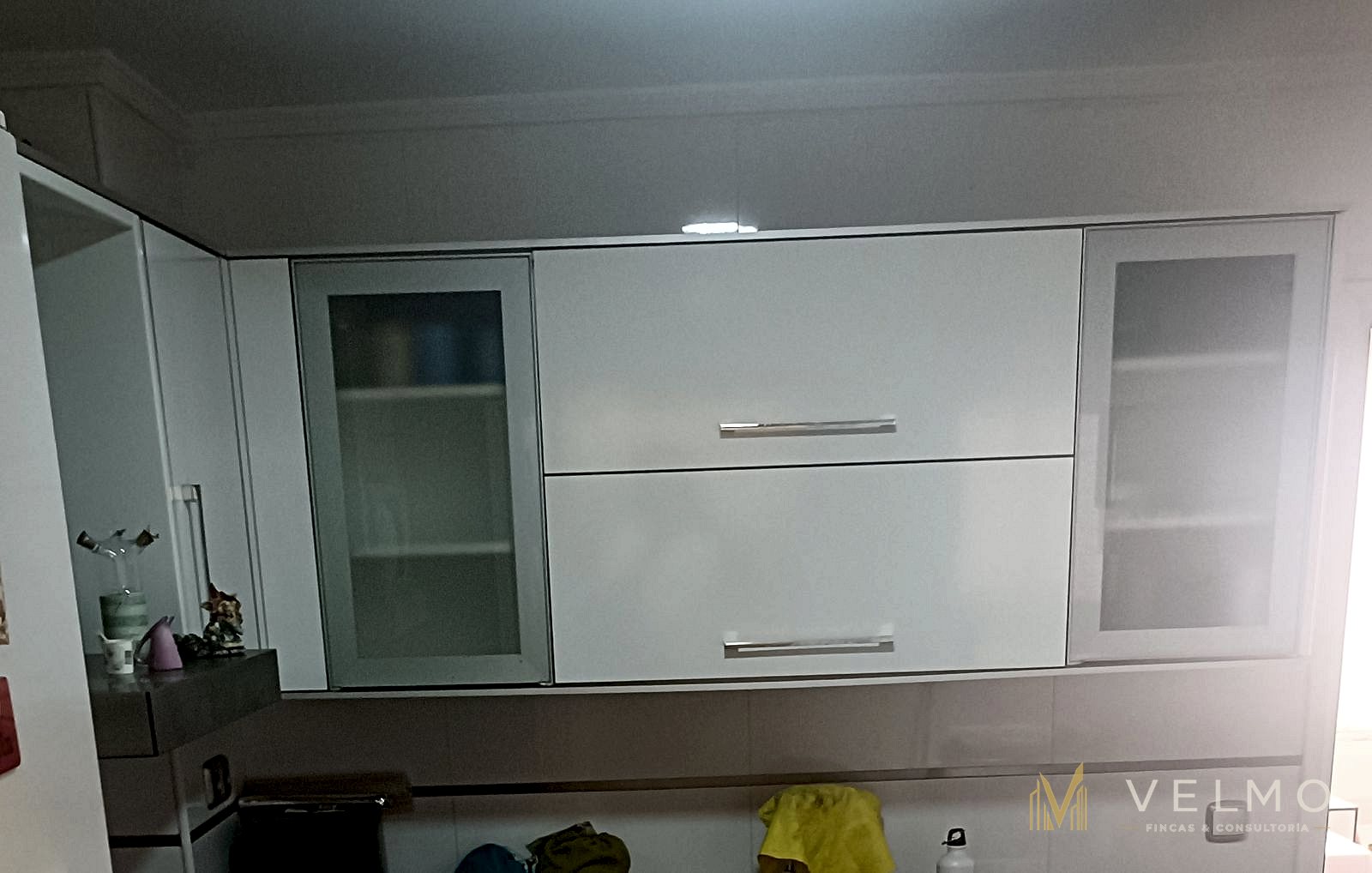 Cocina, detalle de los armarios altos con puertas de cristal