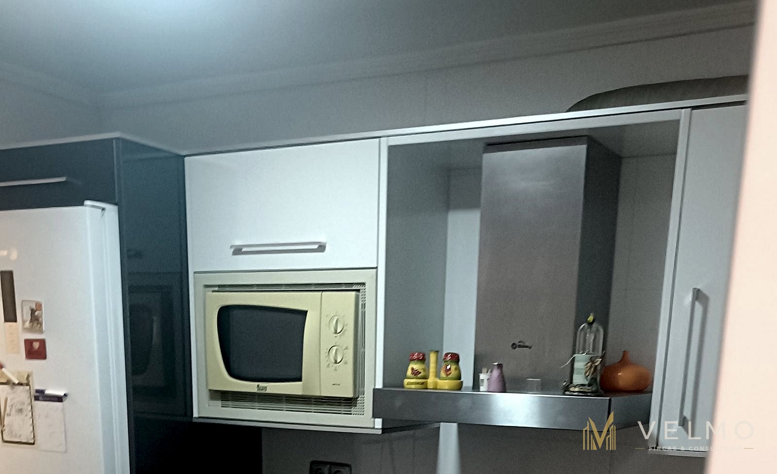 Cocina, detalle de los muebles altos con microondas integrado y campana extractora